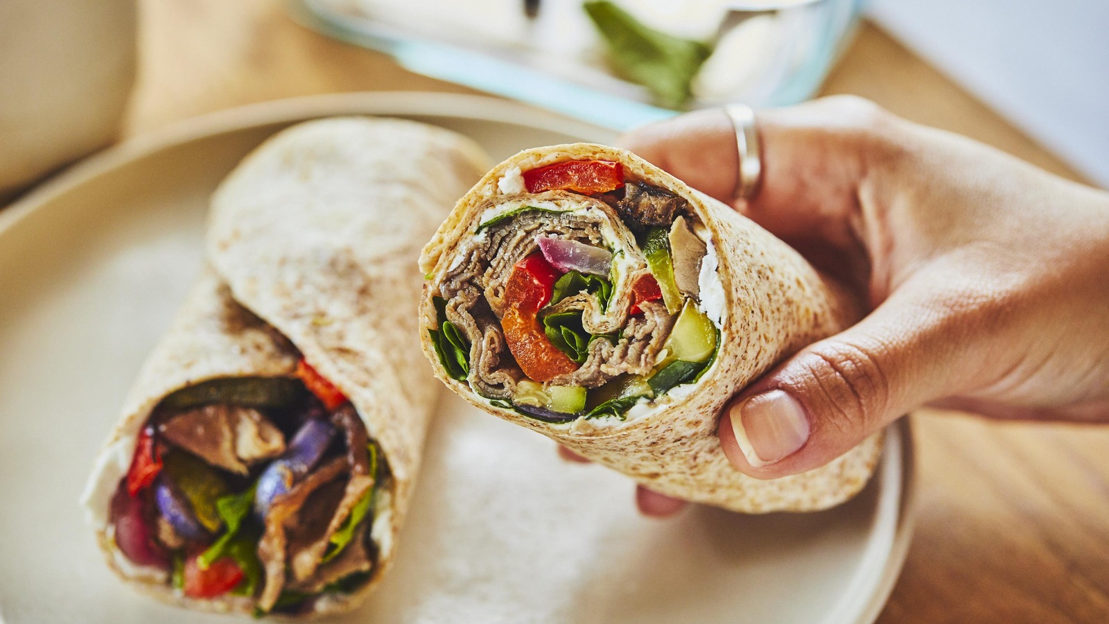 Une personne tient un wrap dans sa main. Une personne tient un wrap dans sa main.