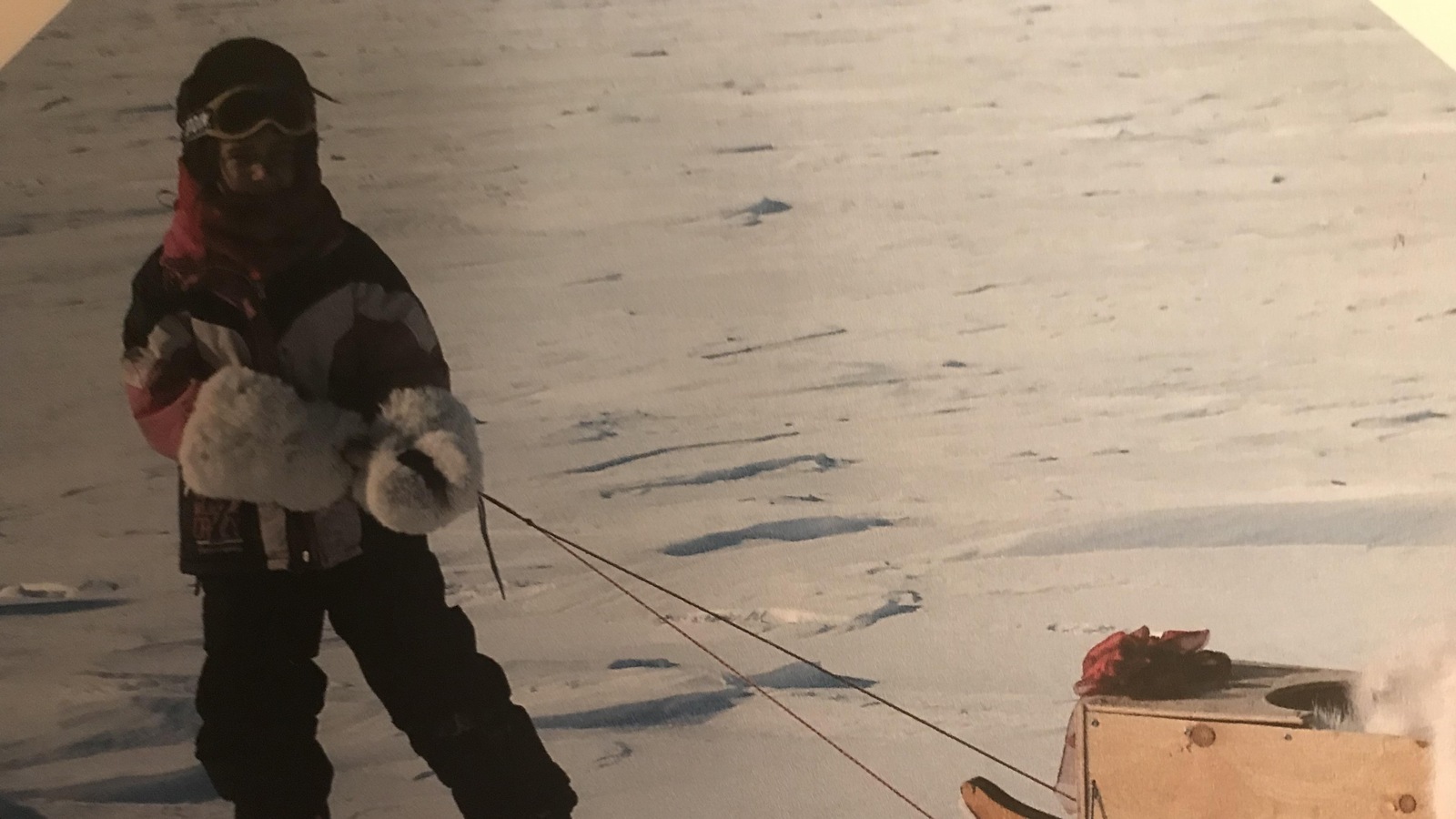 Une jeune enfant tirant un traîneau de bois à Iqaluit