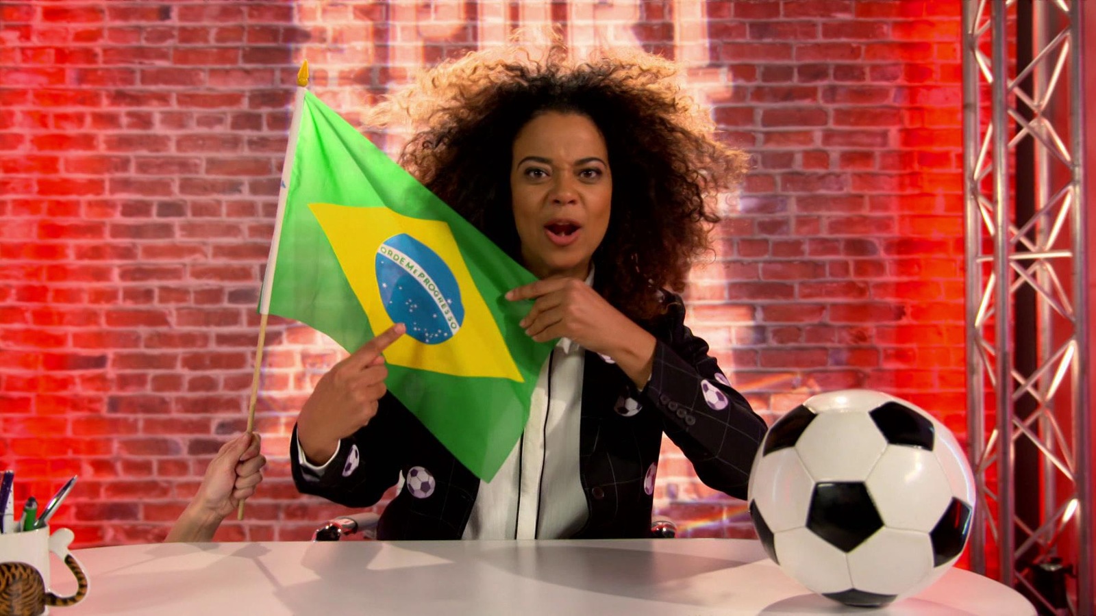 Elle tient le drapeau du Brésil et pose devant un ballon de soccer Elle tient le drapeau du Brésil et pose devant un ballon de soccer