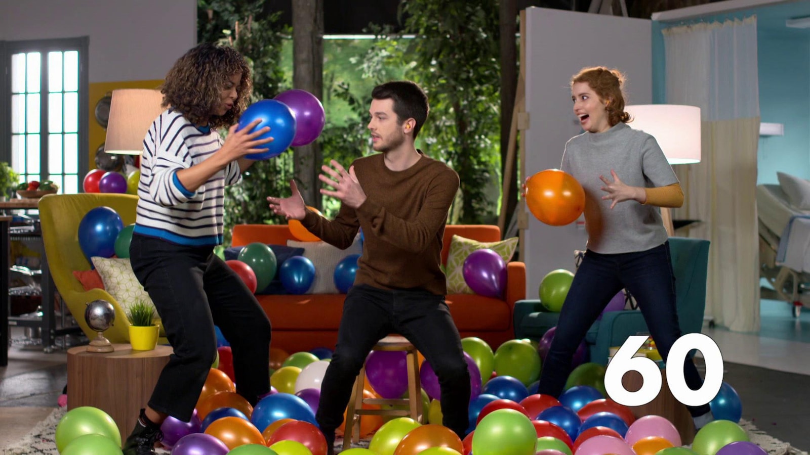 Les trois animateurs rigolent en jouant avec des ballons de toutes les couleurs dans le salon Les trois animateurs rigolent en jouant avec des ballons de toutes les couleurs dans le salon