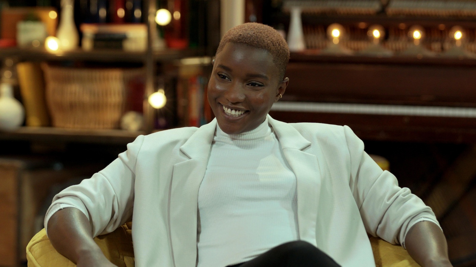 Elle est assise sur un plateau télé et sourit. Elle est assise sur un plateau télé et sourit.
