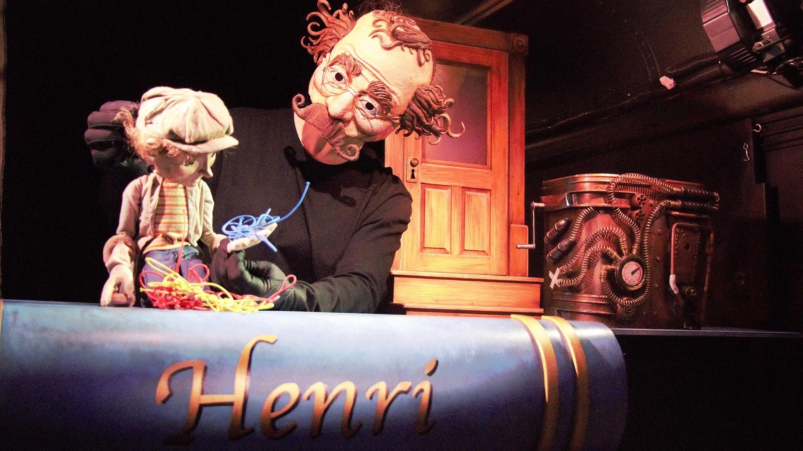 Un comédien masqué manipule la marionnette d'une jeune garçon. Un comédien masqué manipule la marionnette d'une jeune garçon.