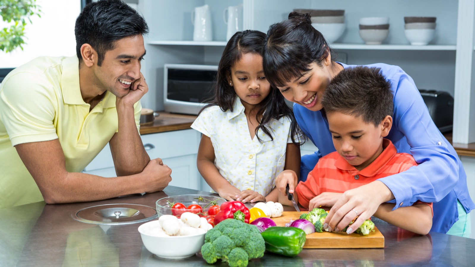 Le petit garçon coupe des légumes Le petit garçon coupe des légumes