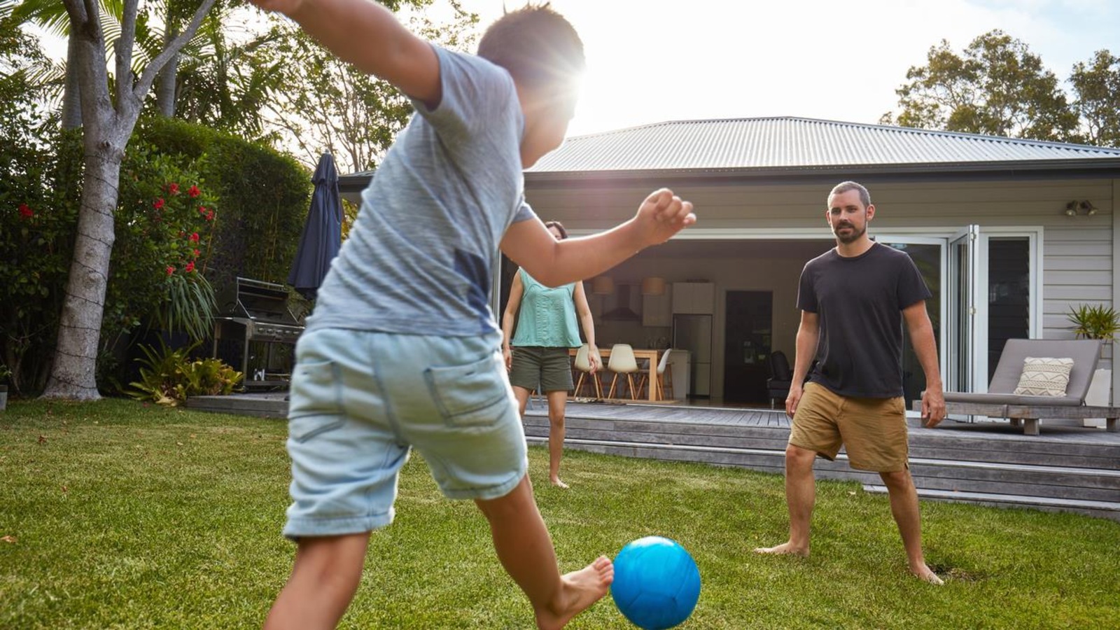 Un jeune garçon s'amuse avec un ballon aux côtés de ses parents. Un jeune garçon s'amuse avec un ballon aux côtés de ses parents.