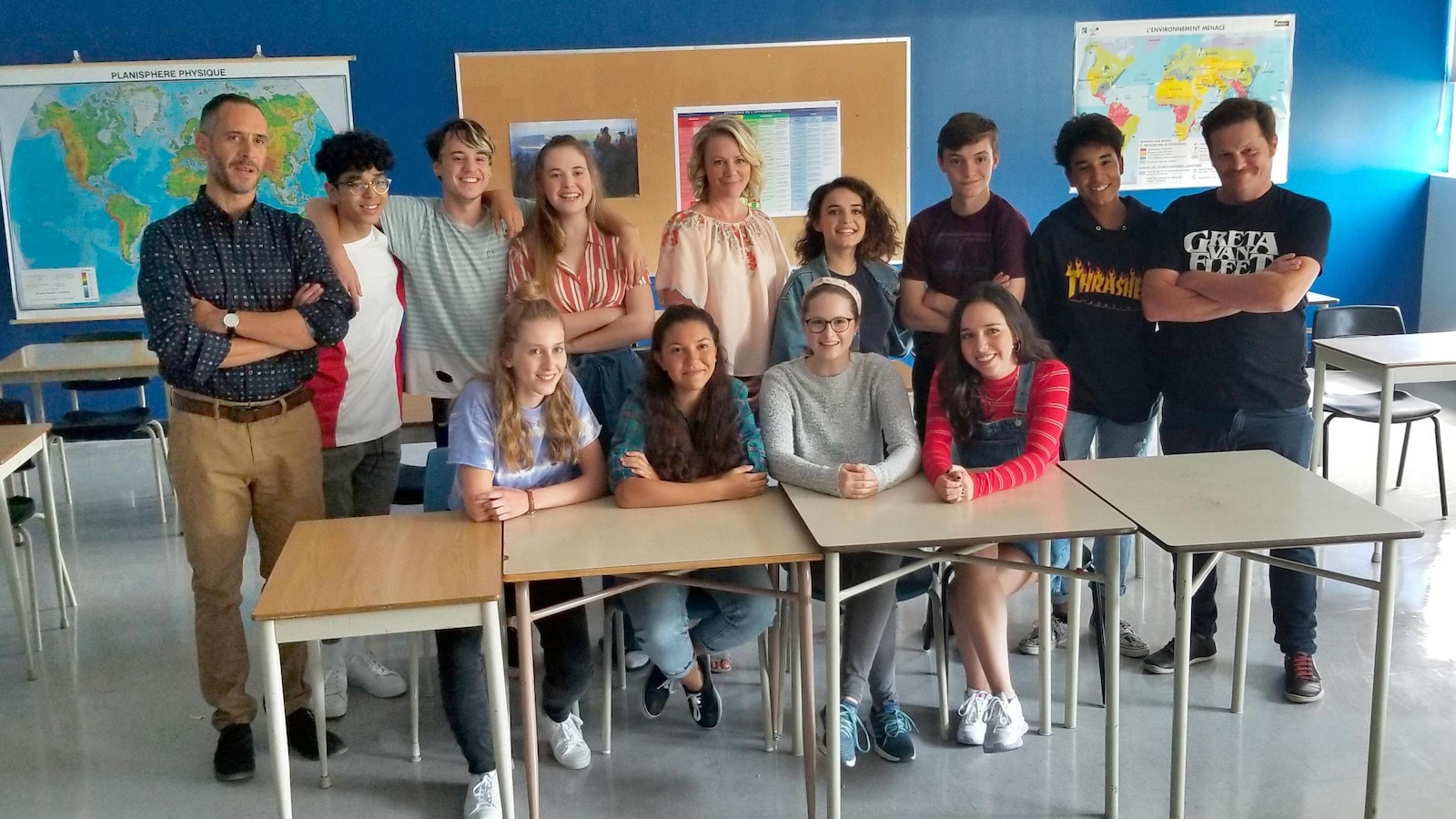 Ils sont assis en salle de classe et sourient Ils sont assis en salle de classe et sourient