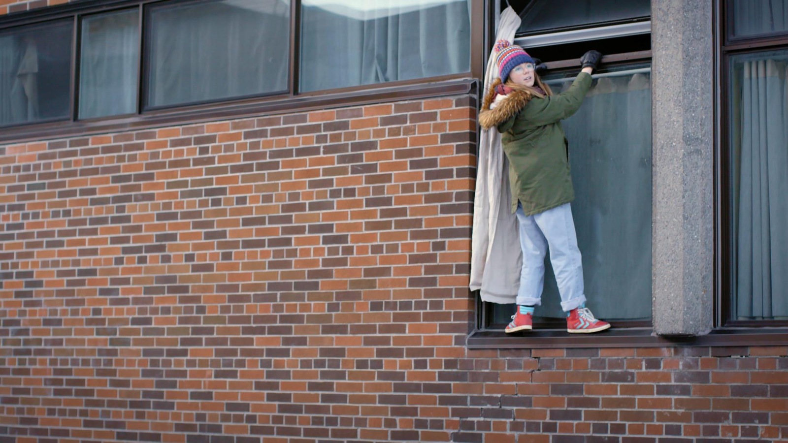 La jeune fille escalade un mur d'école La jeune fille escalade un mur d'école
