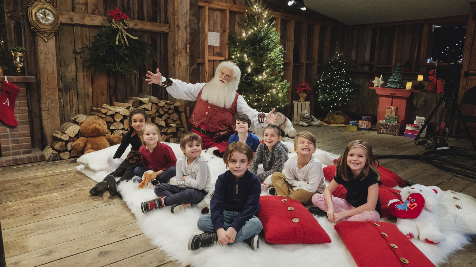 Il pose avec les enfants au chalet de bois Il pose avec les enfants au chalet de bois
