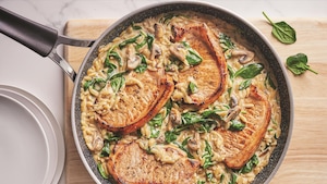 Une casserole remplie de côtelettes de porc et d'orzo à la crème aux champignons.
