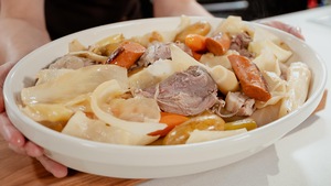 Un plat de service rempli de porc demi-sel et de légumes d'hiver.