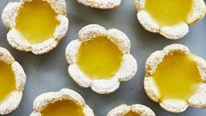 Des petites tartelettes au citron en forme de coeur sont déposées sur un comptoir.