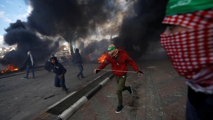 Des Palestiniens courent dans les rues de Beit El, où des incendies ont été allumés.