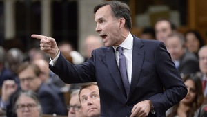 Le ministre des Finances Bill Morneau, de profil, pointe du doigt en direction de l’opposition à la Chambre des communes le 29 novembre 2017 à Ottawa.
