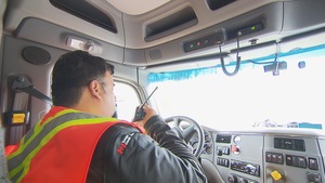 Un camionneur utilise la radio à ondes courtes pour signaler sa présence sur une route forestière en Haute-Mauricie.