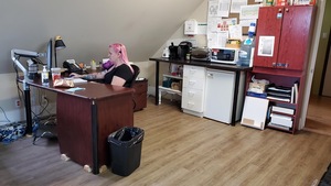 Une femme assise à un bureau est en train de pianoter sur le clavier d'un ordinateur tout en regardant l'écran posé devant elle.