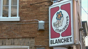L'enseigne de Chaussures Blanchet sur un mur en briques