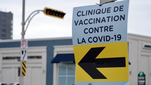 Une affiche montre dans quelle direction se trouve la clinique de vaccination.