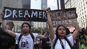 Deux jeunes tiennent des pancartes sur lesquelles sont écrites des slogans en faveur des Dreamers.