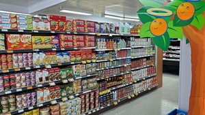 Une allée d'épicerie dont les étagères sont remplies de produits.