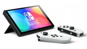 Deux manettes blanches devant une Switch de Nintendo. 