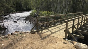 Un pont de bois traverse une rivière.