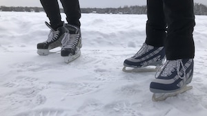 Deux personnes en patin sur l'anneau de glace.