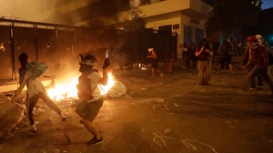Les manifestants sont devant un petit incendie dans la rue.