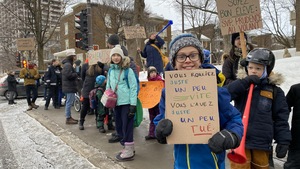 Des écoliers manifestent sur un trottoir près de l'école Anne-Hébert à Québec.