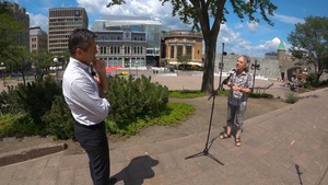 Marc Gourdeau discute avec Bruno Savard, en face du palais Montcalm à Québec. On voit la place d'Youville en arrière-plan.