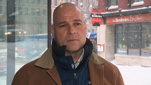 Martin Sirois accorde une entrevue devant les locaux de Radio-Canada situés sur la rue Saint-Jean, au centre-ville de Québec, durant une averse de neige.