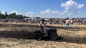Un homme traverse, sur son quatre-roues, une piste de course faite de boue.