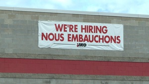 Une affiche indiquant "Nous embauchons" sur le bâtiment d'une entreprise.