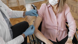 Une personne en chaise roulante reçoit un vaccin.