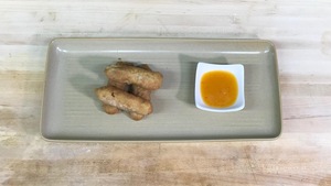Des rouleaux impériaux sont disposés dans une assiette avec une coupole de sauce à la citrouille