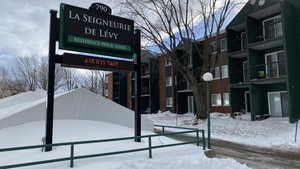 Une pancarte où il est écrit «La seigneurie de Lévy». La pancarte est située juste devant la résidence.
