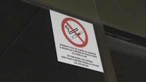 Une pancarte d'interdiction de fumer est affichée dans un établissement.