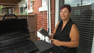 Sylvie Roy, debout sur sa terrasse, exhibe une brosse à BBQ à fils métalliques 