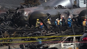 Des pompiers constatent l'ampleur des dégâts du déraillement du train.