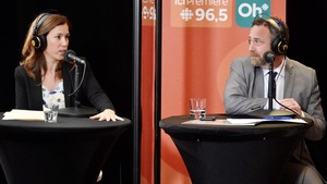 Valérie Renaud-Martin et Jean Lamarche assis à des tables séparés par un plexiglas.