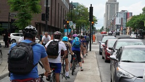Des cyclistes au centre-ville de Montréal attendent au feu de circulation.