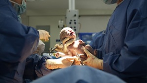 Un bébé vient de naître. Il est dans les mains des médecins.