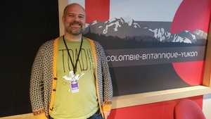 Un homme souriant dans un studio de radio.