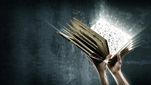 Deux mains tiennent un livre ouvert dont s'échappent des lettres qui volent.