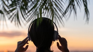 La silhouette d'une femme qui écoute de la musique au coucher du soleil. 