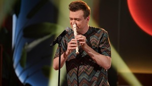 Un homme qui joue de la flûte en soufflant l'air avec son nez.