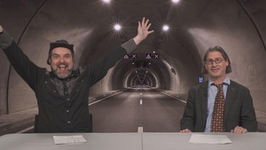 MC Gilles et Jean-René Dufort en plein milieu d'un tunnel (sur un écran derrière eux.).