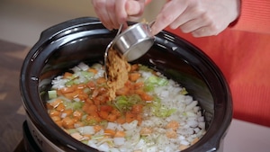 Dans une mijoteuse, on met des légumes, puis on ajoute du miso.