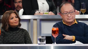 Les deux personnes sont assises en studio.