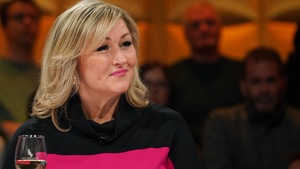 Elle sourit et est assise en studio.