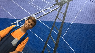 Raphaël devant une murale dans une rue de Montréal.