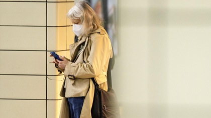 Une femme dans une station de métro consulte son téléphone.